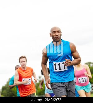 He trained long and hard for this. Cropped front view of a perservering male athlete running in first place. Stock Photo