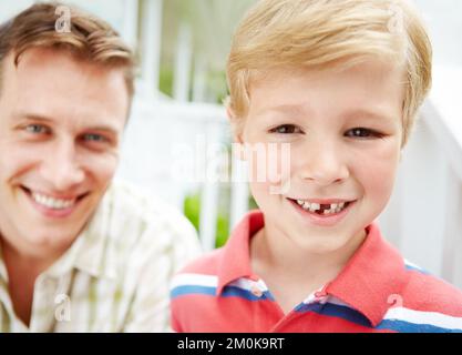 Dad said I was so brave when it fell out. A young boy with a missing tooth spending time with his father. Stock Photo
