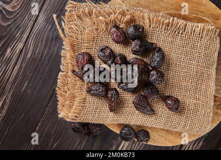 Dried mission figs on burlap and wooden background. Stock Photo