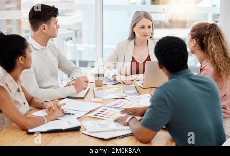 Group of diverse businesspeople having a meeting in an office at work. Focused businesspeople talking during a workshop. Businesspeople planning Stock Photo