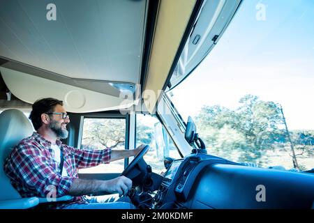 One man driving camper van and enjoying transport road trip travel activity alone. Inside view of motor home and traveling fo holiday vacation concept Stock Photo