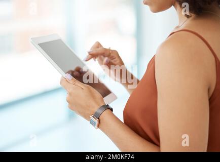 Unrecognizable woman holding and using a digital tablet at home. Unrecognizable woman using social media on a digital tablet at work. Stock Photo