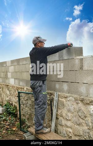 masons building new wall with white brick Stock Photo