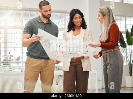 Diverse architects talking about a blueprint. Focused businesspeople planning their strategy. Engineers looking at a building plan. Boss talking to Stock Photo