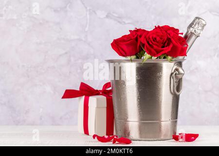 Valentines day card with champagne, rose flowers and gift box. With space for your greetings Stock Photo