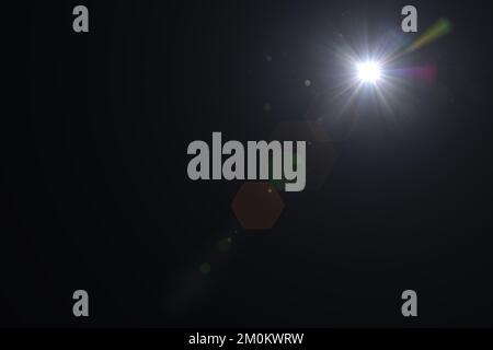 Solar lens flare on black background. Lens Flare light over black background. Easy to add overlay or screen filter over photos. Stock Photo