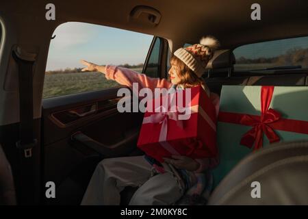 Woman in car with Christmas presents Stock Photo