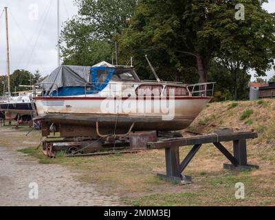 Old weathered boat in a shipyard ready to be restored Stock Photo