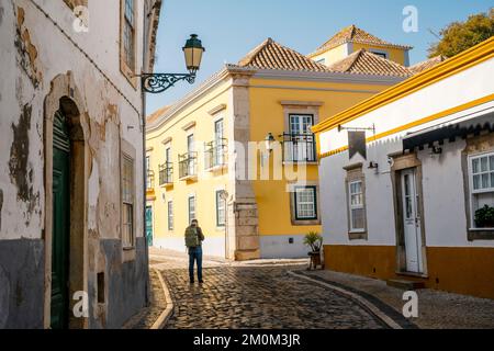 A tourist with backpack exploring Faro, capital city of Algarve, Portugal Stock Photo