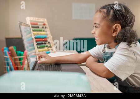Home learning, online education and girl with happiness studying math on a digital computer app. School study, smile and kid on technology working on Stock Photo