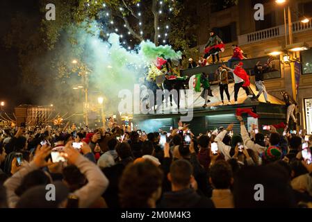 Barcelona, Spain. 06th Dec, 2022. People use smoke flares to celebrate the victory of the Morocco football team over Spain in the Ramblas street after the football match. In a surprise victory, the Moroccan team beat Spain at the penalties, passing to the quarterfinals, where it will face Portugal, for the first in its history. Credit: SOPA Images Limited/Alamy Live News Stock Photo