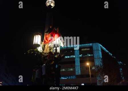 Barcelona, Spain. 06th Dec, 2022. People hold the Moroccan flag to celebrate the victory of the Morocco football team over Spain in the city center after the football match. In a surprise victory, the Moroccan team beat Spain at the penalties, passing to the quarterfinals, where it will face Portugal, for the first in its history. Credit: SOPA Images Limited/Alamy Live News Stock Photo