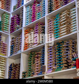 Many colorful threads on the shelfs in a workshop Stock Photo