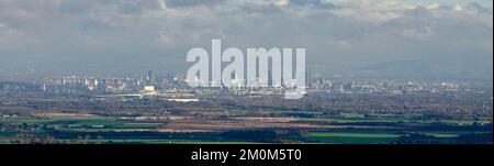 A distant panoramic view from the west, of Manchester City Centre, with the pennines behind, north West England, UK Stock Photo