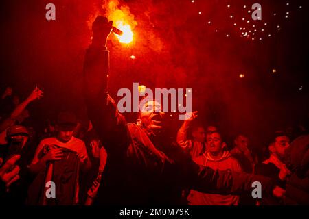 Barcelona, Spain. 06th Dec, 2022. Supporters of the Moroccan soccer team celebrate their victory over Spain in the Qatar 2022 World Cup with lit red flares on La Rambla in Barcelona. The Moroccan community residing in Barcelona went out to celebrate their pass to the quarterfinals on the Ramblas of Barcelona after beating the Spanish team in the Qatar 2022 World Cup. Credit: SOPA Images Limited/Alamy Live News Stock Photo