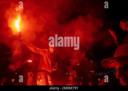 Barcelona, Spain. 06th Dec, 2022. Supporters of the Moroccan soccer team celebrate their victory over Spain in the Qatar 2022 World Cup with lit red flares on La Rambla in Barcelona. The Moroccan community residing in Barcelona went out to celebrate their pass to the quarterfinals on the Ramblas of Barcelona after beating the Spanish team in the Qatar 2022 World Cup. Credit: SOPA Images Limited/Alamy Live News Stock Photo