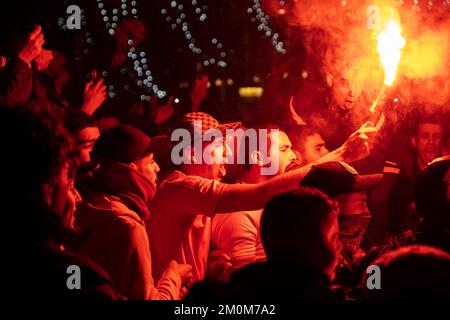 Barcelona, Spain. 06th Dec, 2022. Supporters of the Moroccan soccer team celebrate their victory over Spain in the Qatar 2022 World Cup with lit red flares on La Rambla in Barcelona. The Moroccan community residing in Barcelona went out to celebrate their pass to the quarterfinals on the Ramblas of Barcelona after beating the Spanish team in the Qatar 2022 World Cup. Credit: SOPA Images Limited/Alamy Live News Stock Photo