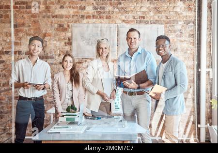 Group of diverse architects discussing plans, blueprints and schematics during a meeting in their office boardroom. Business people brainstorming and Stock Photo