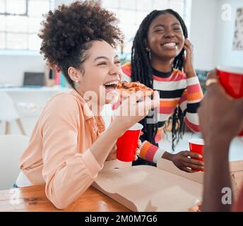 Young cheerful mixed race businesswoman eating lunch with hr colleagues at work. Group of joyful coworkers having pizza together in an office at work Stock Photo