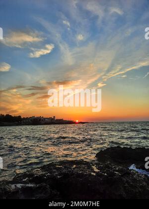 Colorful sunset over wavy blue dark sea, orange and blue sky, escape from city life, nature Stock Photo