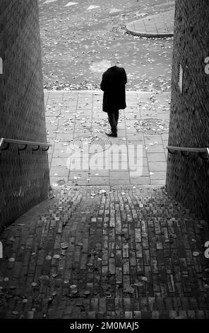 Man without head smoking on street at the bottom of stairs. Stock Photo