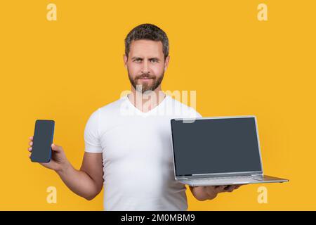 guy showing screen with copy space. guy showing phone screen isolated on yellow background. Stock Photo