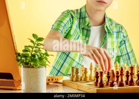 Teenage boy learning to play chess online with tablet computer