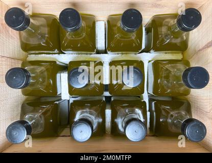 Olive oil bottles filled in wooden crate. Olive oil bottles prepared for shipping in glass bottles. Stock Photo
