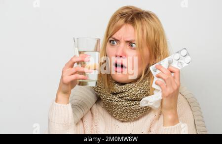 Ways to feel better fast. Flu home remedies. Get rid of flu. Woman wear warm scarf because illness or flu. Girl hold glass water tablets and Stock Photo
