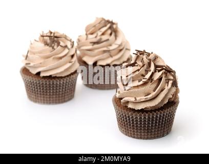 Three chocolate cupcakes with whipped cream and chocolate sprinkles isolated on white Stock Photo