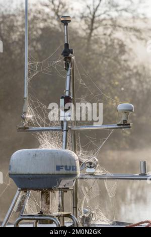 Stainless steel masthead of moored small motor boat (on tidal river mooring). Navigation lights and Furuno radar radome visible. Stock Photo