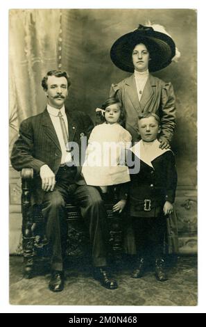 Original, Titanic era studio portrait postcard of attractive middle class family, fashionably dressed, with 2 small children, taken on 7th August 1911, at the Cooper Brothers Studio, Yonkers, New York. The family's home was 92 Park Hill Avenue, Kellinger street, Yonkers, U.S.A. Stock Photo