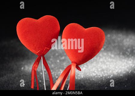 Valentine's Day, two red loving hearts on a black background. Stock Photo