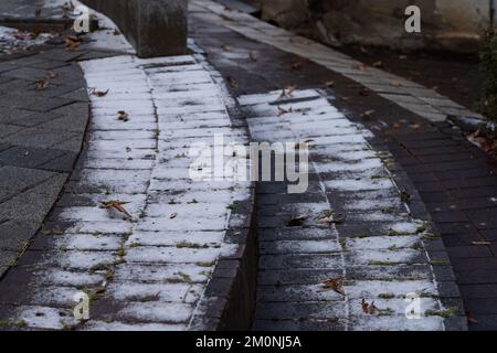 It is a wide staircase with a curved surface covered with fallen leaves and a little snow. Stock Photo