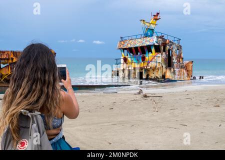 Tourist photographing a cargo ship stranded on Manzanillo beach on the Caribbean coast of Costa Rica Stock Photo