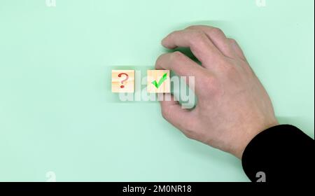 Hand making a choice between two cubes with Yes and No on neutral background. Stock Photo