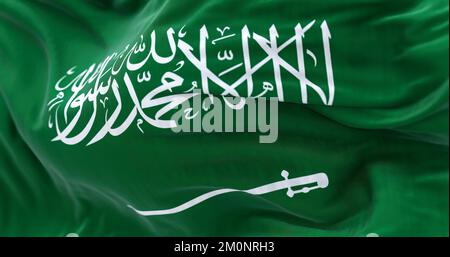 Close-up view of Saudi Arabia national flag waving in the wind. The Kingdom of Saudi Arabia is a country in Western Asia. Fabric textured background. Stock Photo