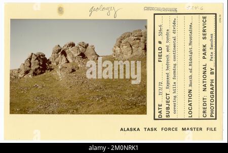 Exposed bedrock and tundra covering hills forming continental divide