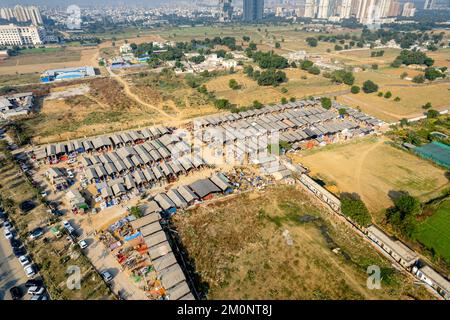 aerial drone decending shot of banjara market in gurgaon delhi showing disorganized temporary tents houses in slums showing this famous handicraft and Stock Photo