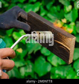 Wood fire treatment with a gas burner. DIY process. Stock Photo