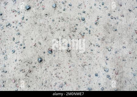 View of a pedestrian path made of pressed sand strewn with small pebbles for use as an abstract background and texture. Stock Photo