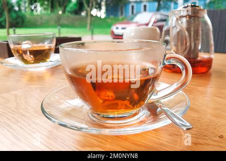 A transparent glass cup of tea stands on the table Stock Photo