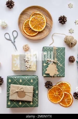 Hand crafted gifts on dark background with Christmas decorations. Seasonal background shot from above. Flat lay, top view. Stock Photo