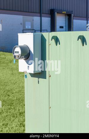 Vertical format image of close-up of electric meter behind commercial building Stock Photo