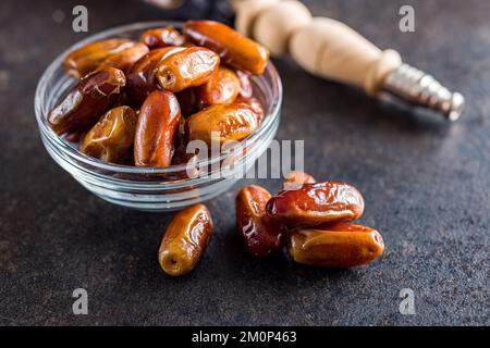 Dried dates fruit in bowl on the black table. Stock Photo