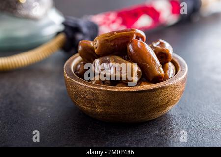 Dried dates fruit in bowl on the black table. Stock Photo