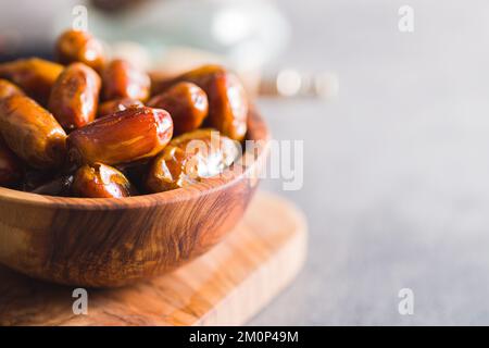 Dried dates fruit in the wooden bowl. Stock Photo