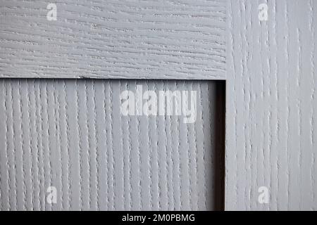 Fragment of furniture made of natural solid ash wood. The joint of planks door of cabinet door painted grey moss color. Stock Photo