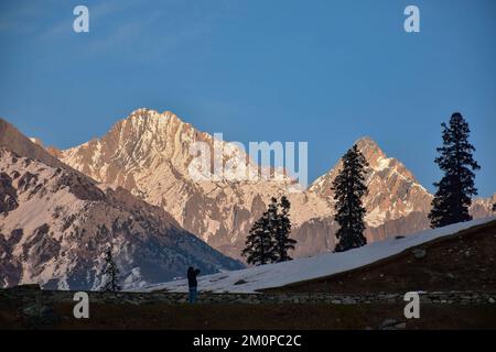 Sonamarg, India. 07th Dec, 2022. A visitor walks along the road during a cold winter evening in Sonamarg, about 100kms northeast of Srinagar, the summer capital of Jammu and Kashmir. (Photo by Saqib Majeed/SOPA Images/Sipa USA) Credit: Sipa USA/Alamy Live News Stock Photo