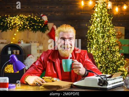 Smiling man in red leather jacket with mug of milk and cookie. Merry Christmas. New year background. Stock Photo